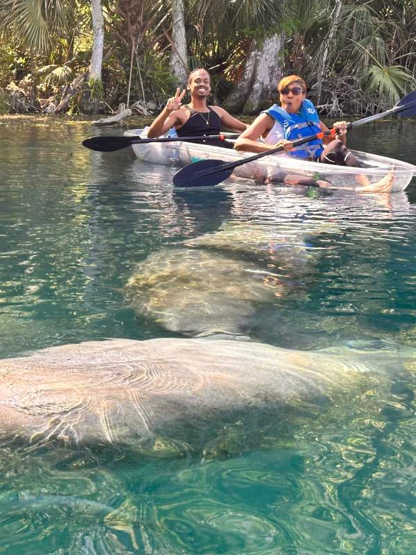 a group of people riding on the back of a boat in the water