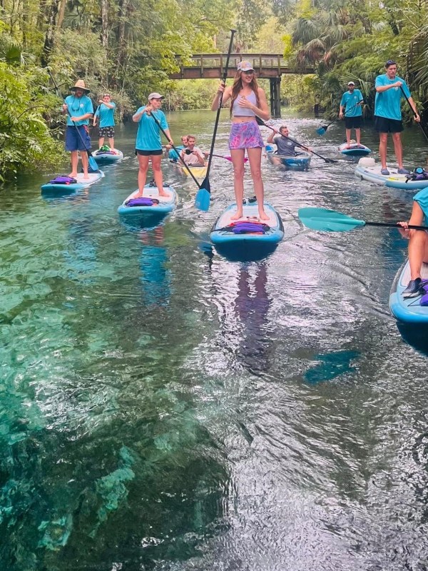 a group of people riding on the back of a boat in the water